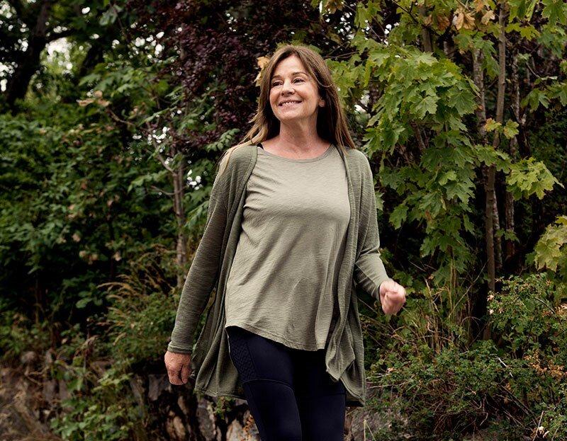 Woman walking outdoors in nature, representing personal growth and adjusting to a new chapter of life.