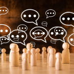 Wooden figurines surrounded by speech bubbles, representing conversations, social interactions, and overthinking after a conversation.