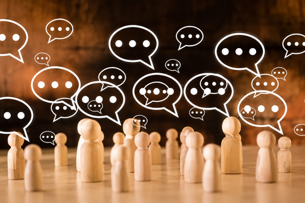 Wooden figurines surrounded by speech bubbles, representing conversations, social interactions, and overthinking after a conversation.