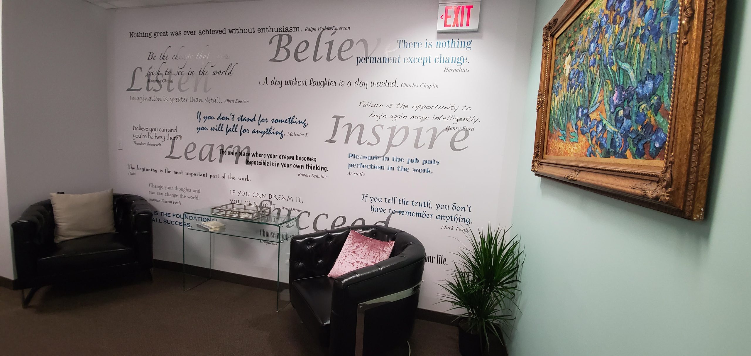 Modern office space featuring motivational quotes, a framed painting, and comfortable seating