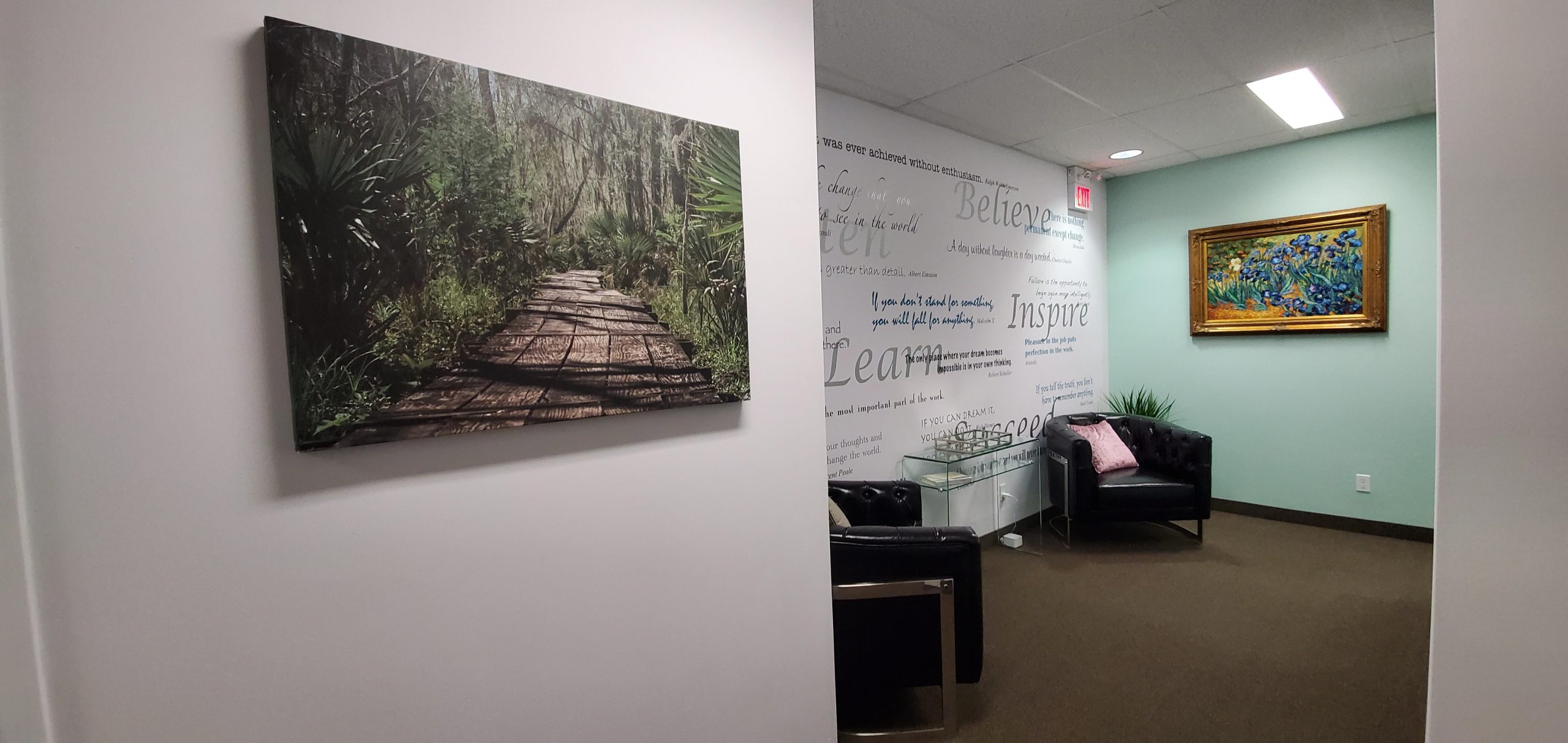 Wooden pathway artwork on wall beside a seating area with inspirational quotes